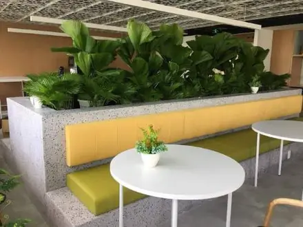 a built-in terrazzo-clad bench and planter box in a lounge seating area