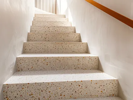 a staircase finished with speckled terrazzo treads and risers
